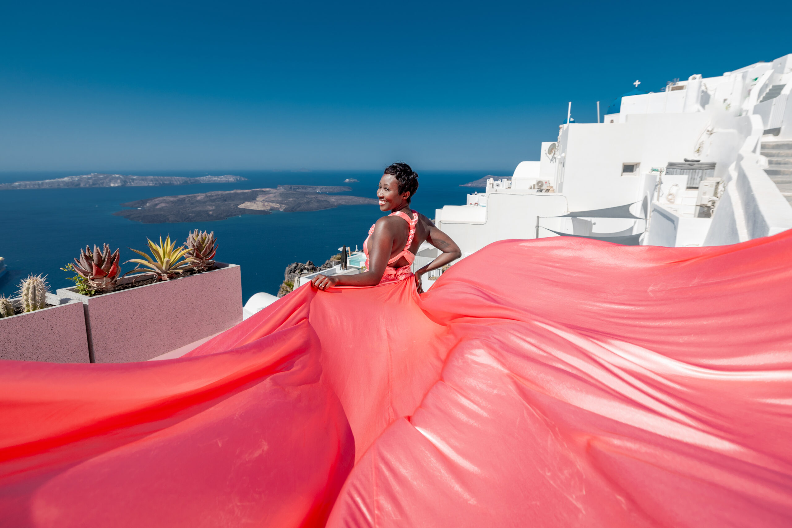 Santorini Photographer. Santorini photo shoot with flying dress. Santorini Photoshoot. Flying Dress Photoshoot in Santorini. Santorini Photography. Group Santorini photoshoot