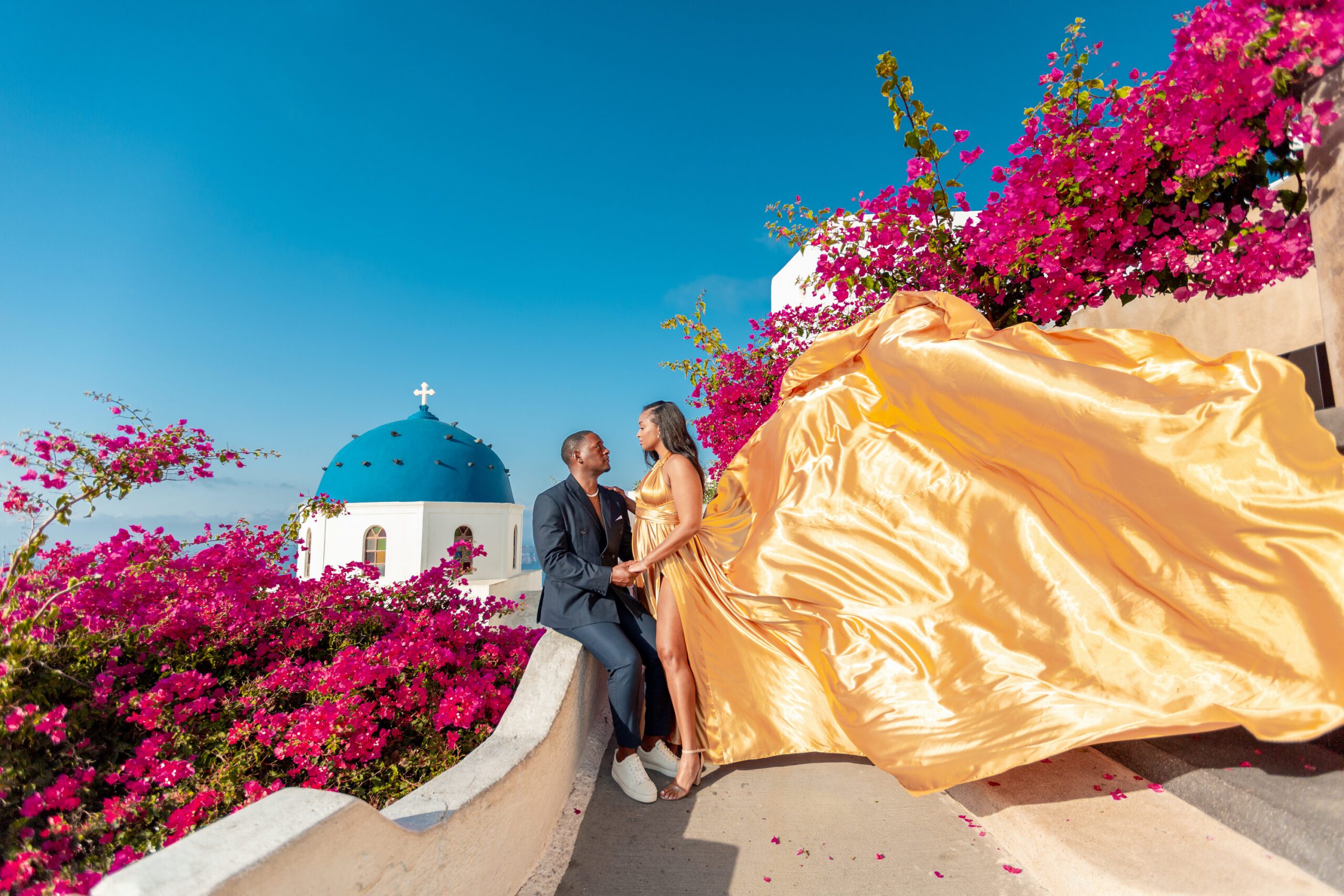 Santorini Photographer. Santorini photo shoot with flying dress. Santorini Photoshoot. Flying Dress Photoshoot in Santorini. Santorini Photography. Group Santorini Photoshoot