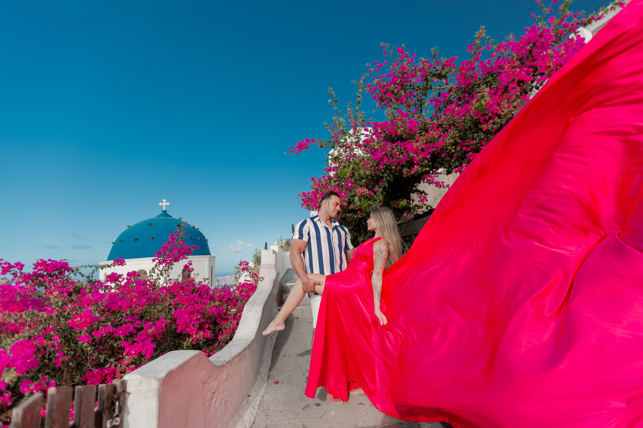 Santorini Photographer. Santorini photo shoot with flying dress. Santorini Photoshoot. Flying Dress Photoshoot in Santorini. Santorini Photography. Group Santorini photoshoot