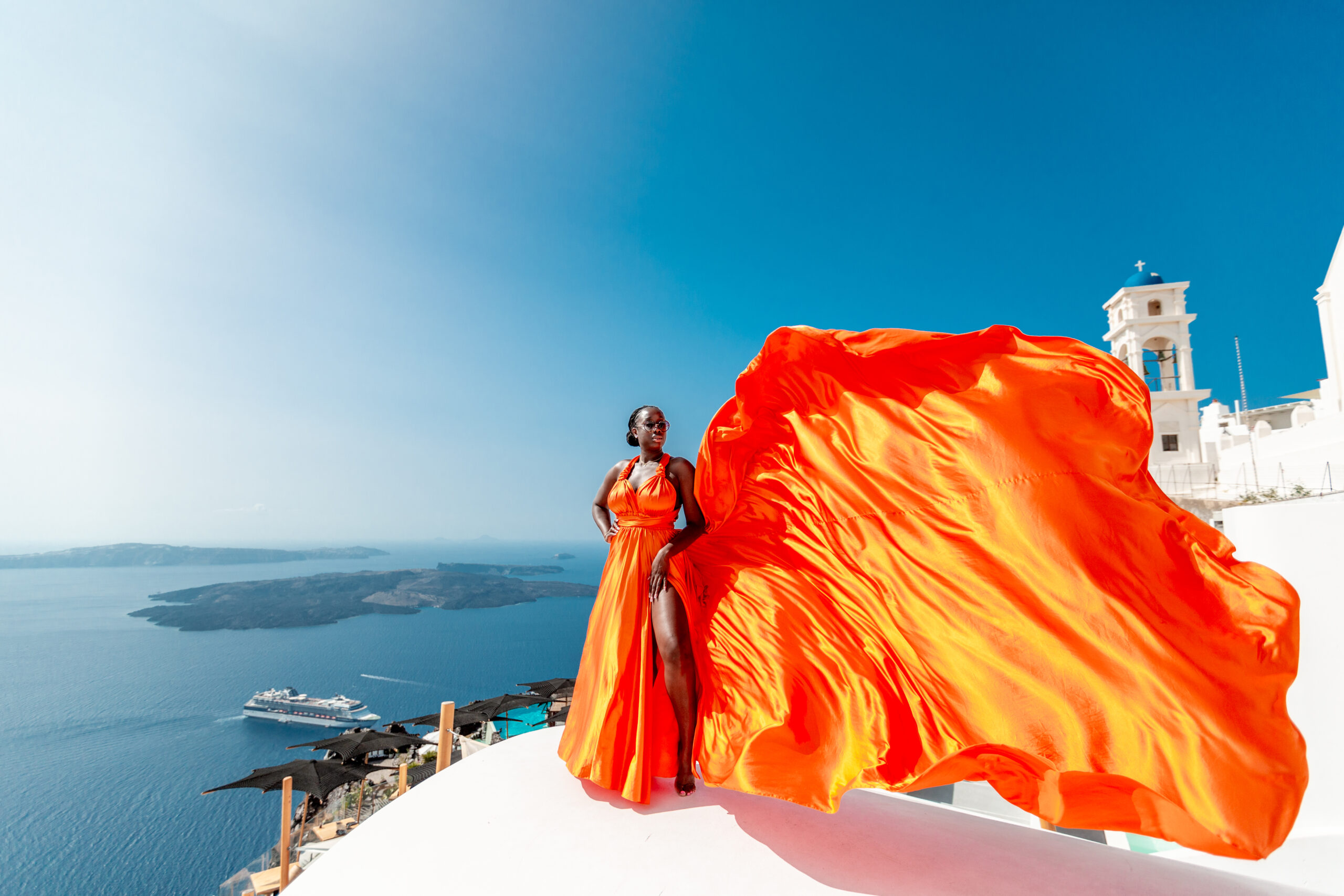 Santorini Photographer. Santorini photo shoot with flying dress. Santorini Photoshoot. Flying Dress Photoshoot in Santorini. Santorini Photography. Group Santorini photoshoot