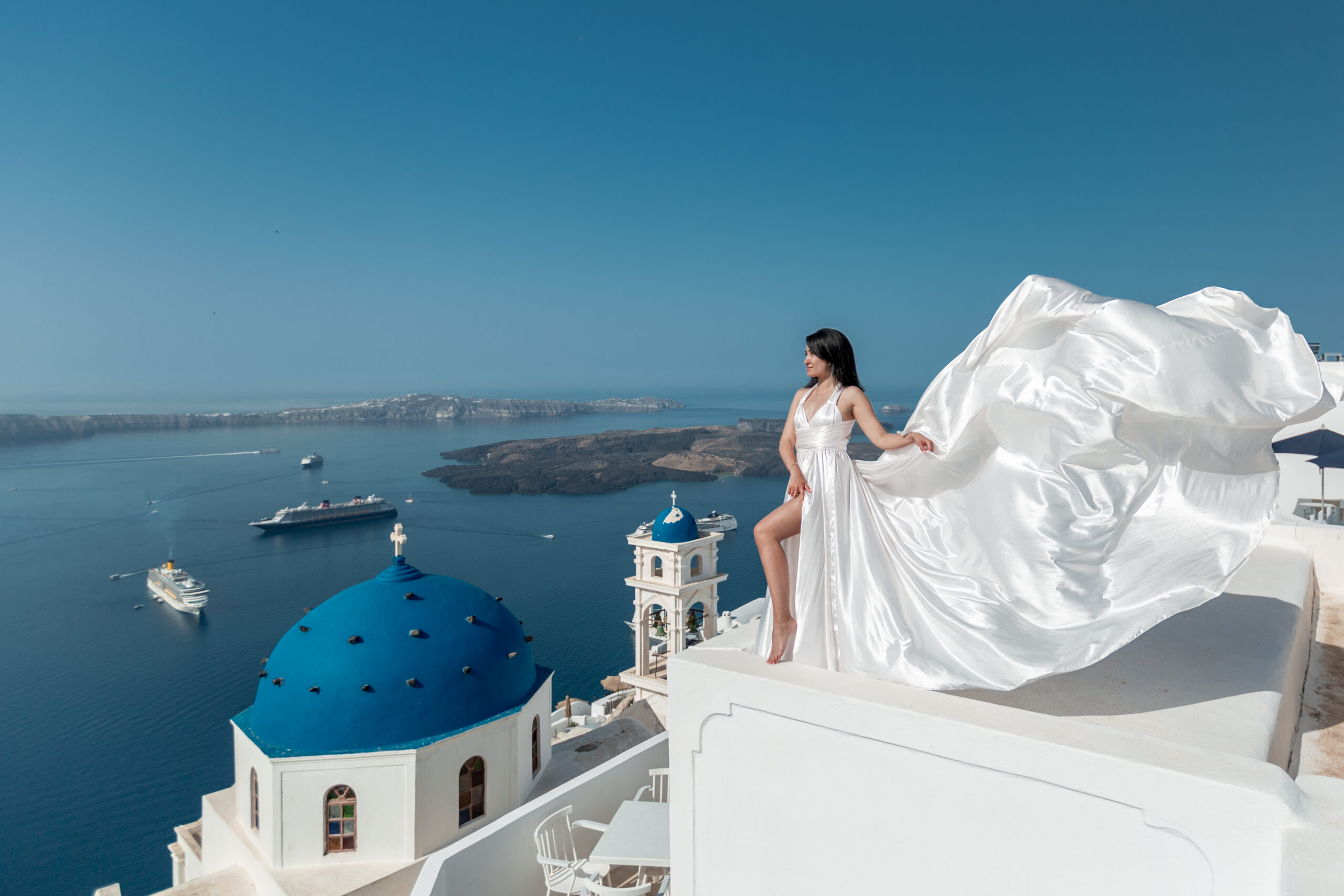 Santorini Photographer. Santorini photo shoot with flying dress. Santorini Photoshoot. Flying Dress Photoshoot in Santorini. Santorini Photography. Group Santorini photoshoot
