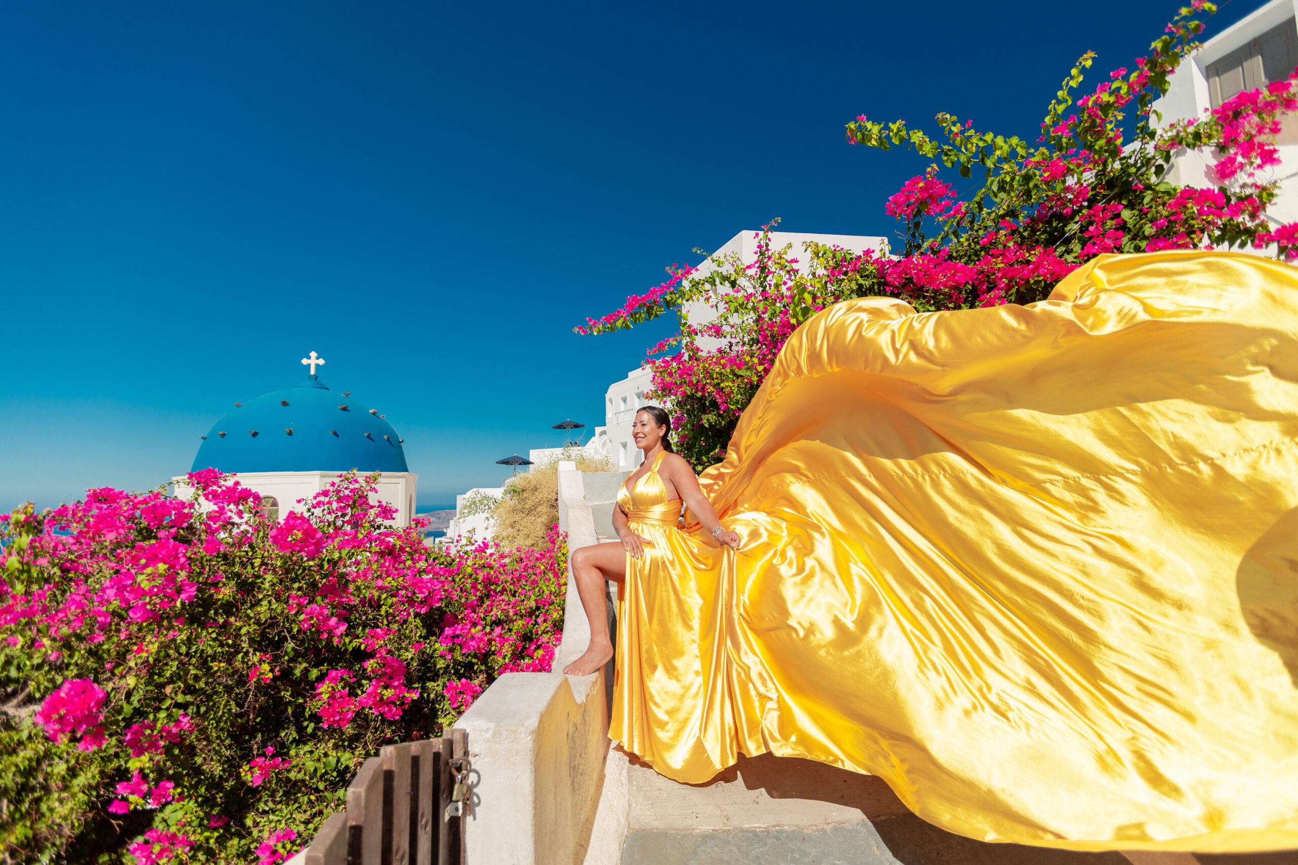 Santorini Photographer. Santorini photo shoot with flying dress. Santorini Photoshoot. Flying Dress Photoshoot in Santorini. Santorini Photography. Group Santorini photoshoot
