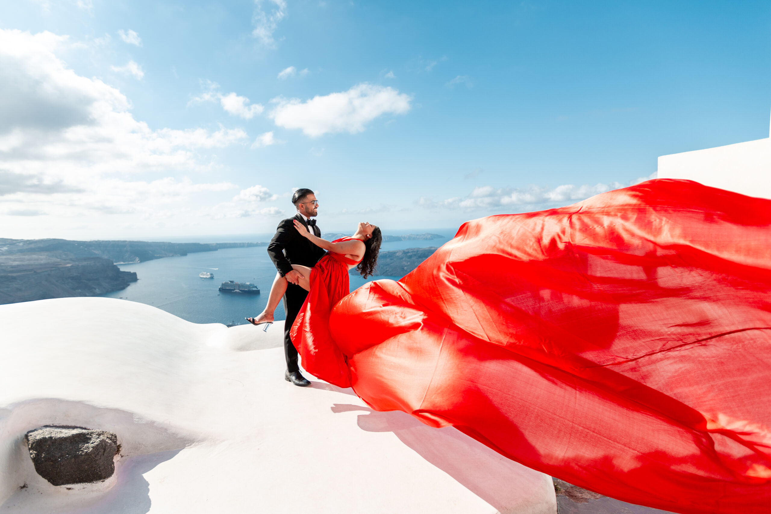 Santorini love story photoshoot. Santorini Photographer. Santorini. Santorini Photoshoot. Flying Dress Photoshoot in Santorini. Santorini Photography. Proposal Santorini