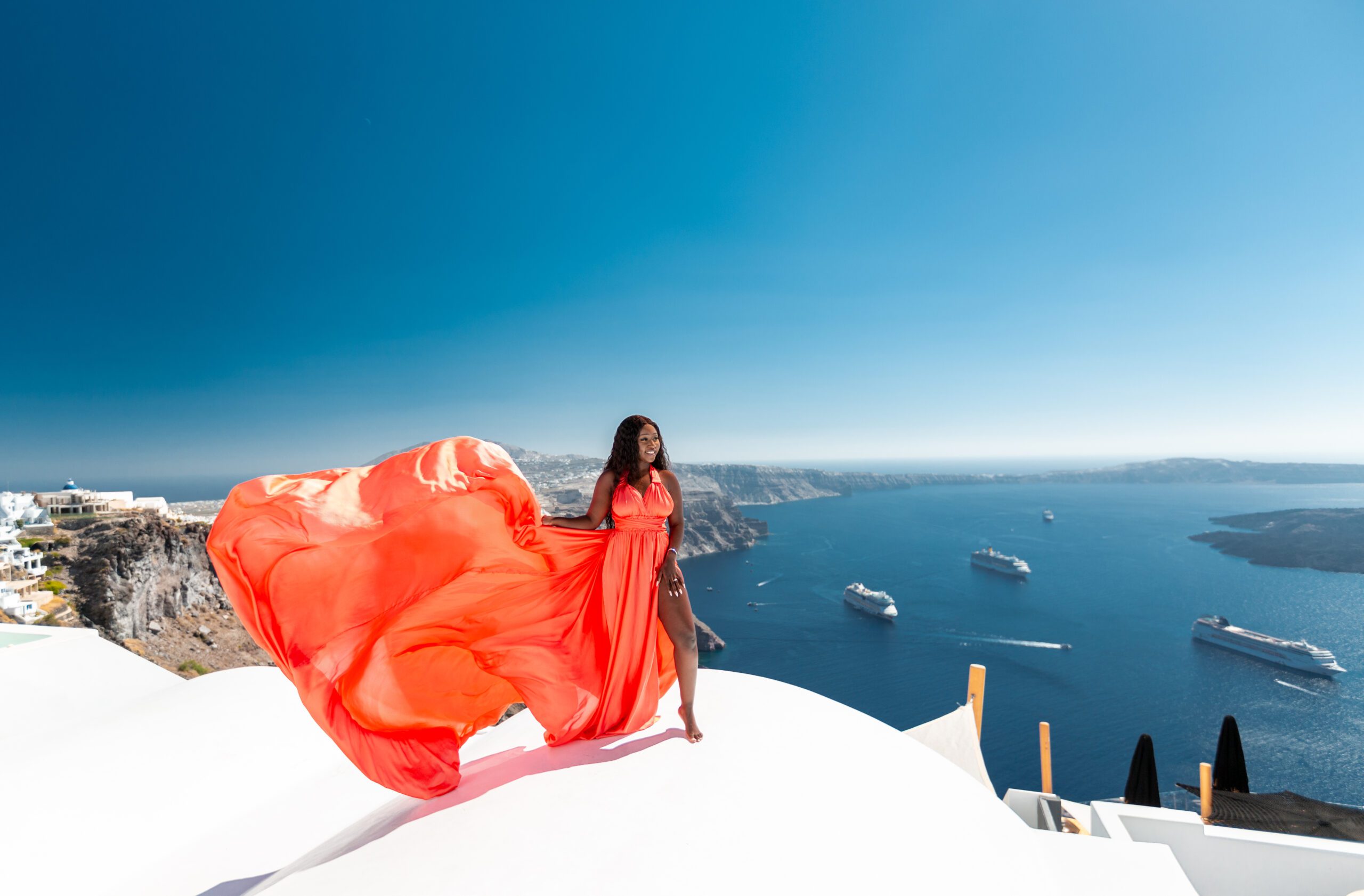 Santorini Photographer. Santorini photo shoot with flying dress. Santorini Photoshoot. Flying Dress Photoshoot in Santorini. Santorini Photography. Group Santorini photoshoot