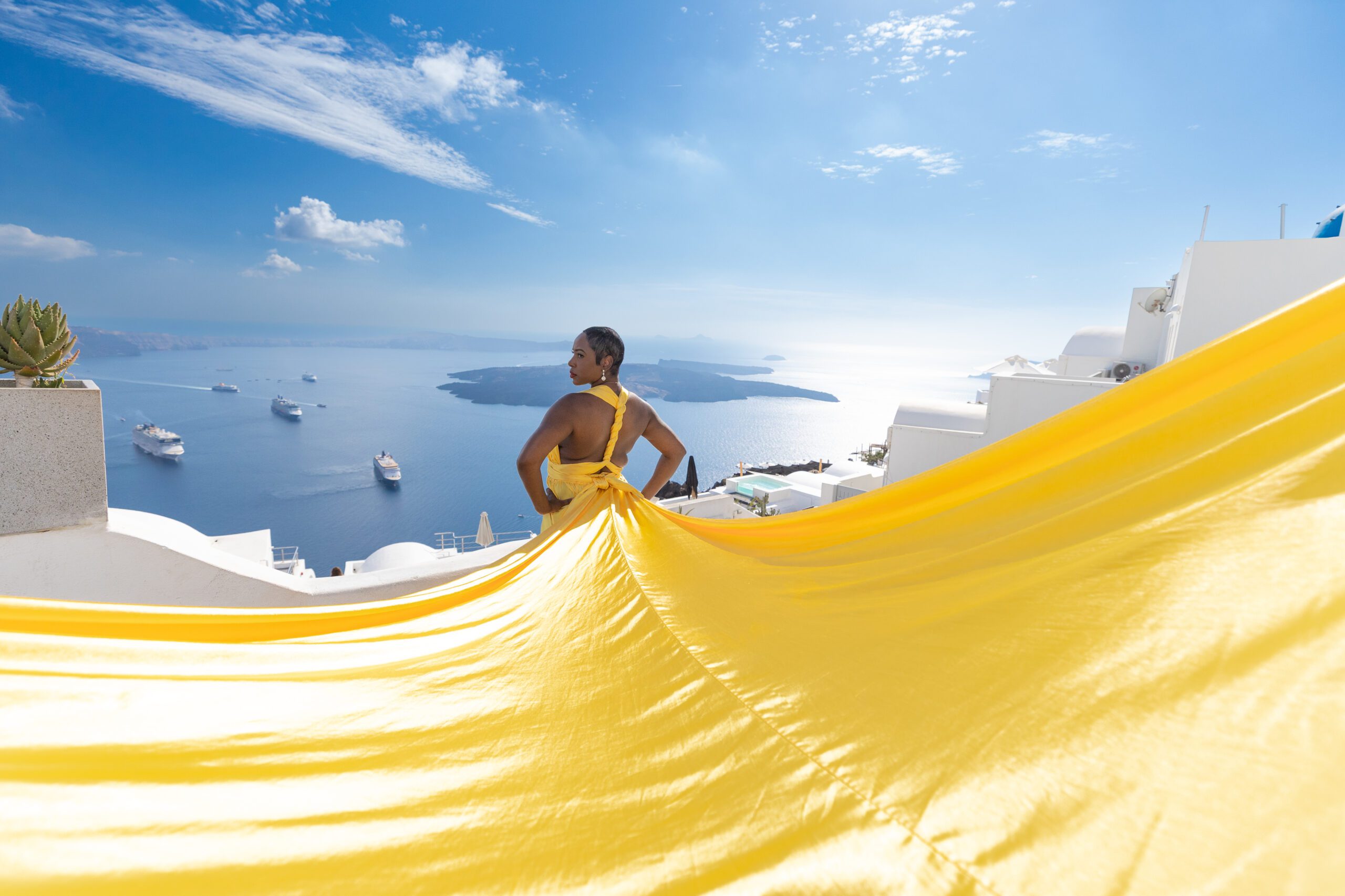 Santorini Photographer. Santorini photo shoot with flying dress. Santorini Photoshoot. Flying Dress Photoshoot in Santorini. Santorini Photography. Group Santorini photoshoot
