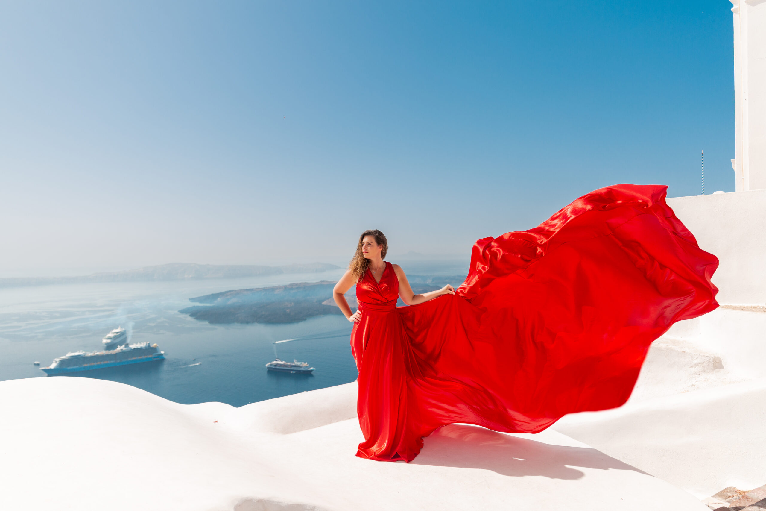 Santorini Photographer. Santorini photo shoot with flying dress. Santorini Photoshoot. Flying Dress Photoshoot in Santorini. Santorini Photography. Group Santorini photoshoot