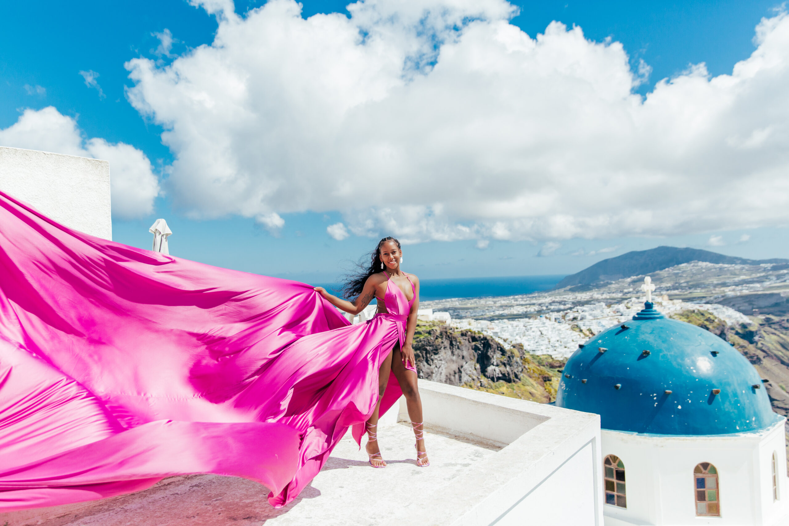 Santorini Photographer. Santorini photo shoot with flying dress. Santorini Photoshoot. Flying Dress Photoshoot in Santorini. Santorini Photography. Group Santorini photoshoot