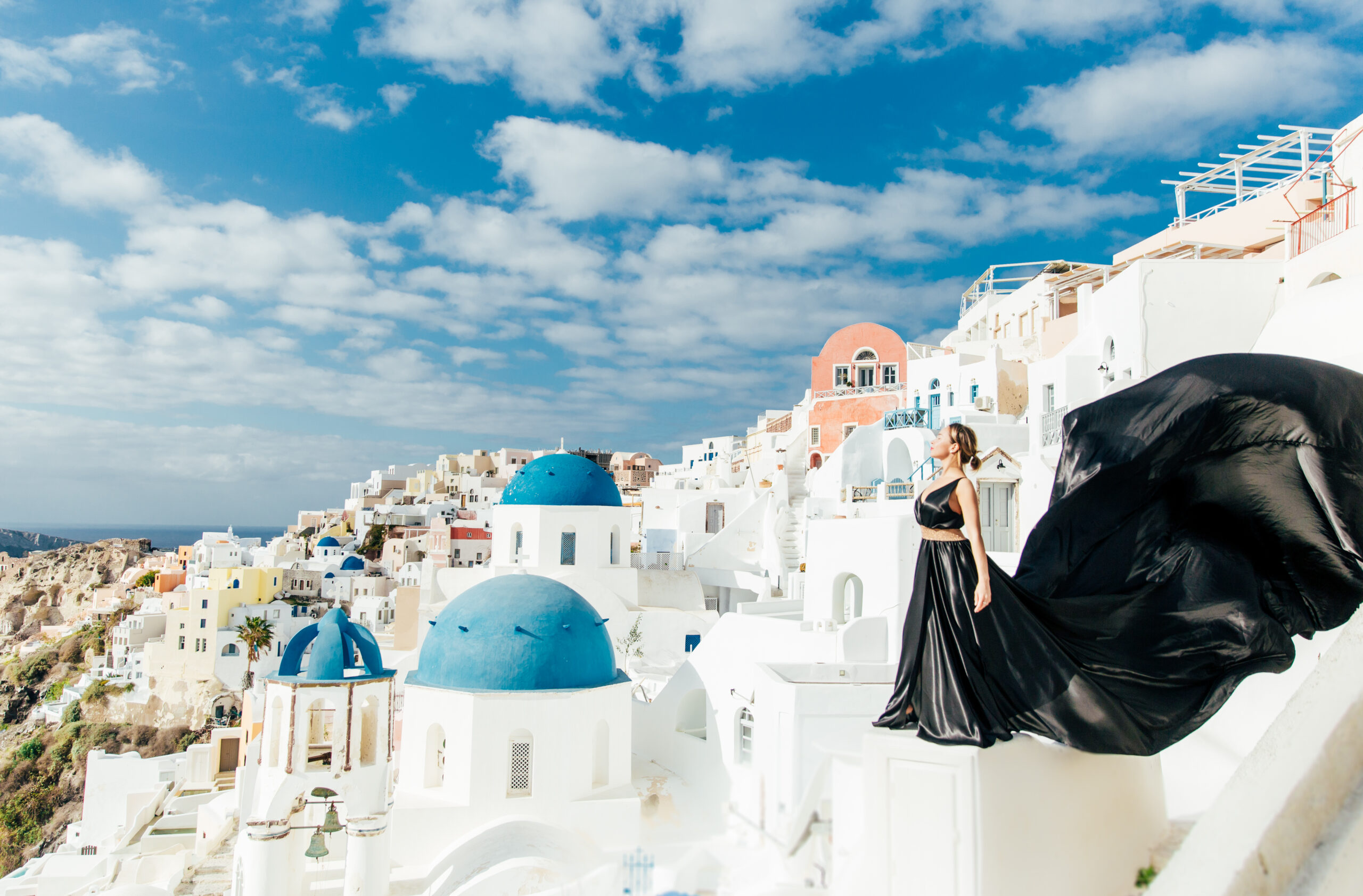 Santorini Photographer. Santorini photo shoot with flying dress. Santorini Photoshoot. Flying Dress Photoshoot in Santorini. Santorini Photography. Group Santorini photoshoot