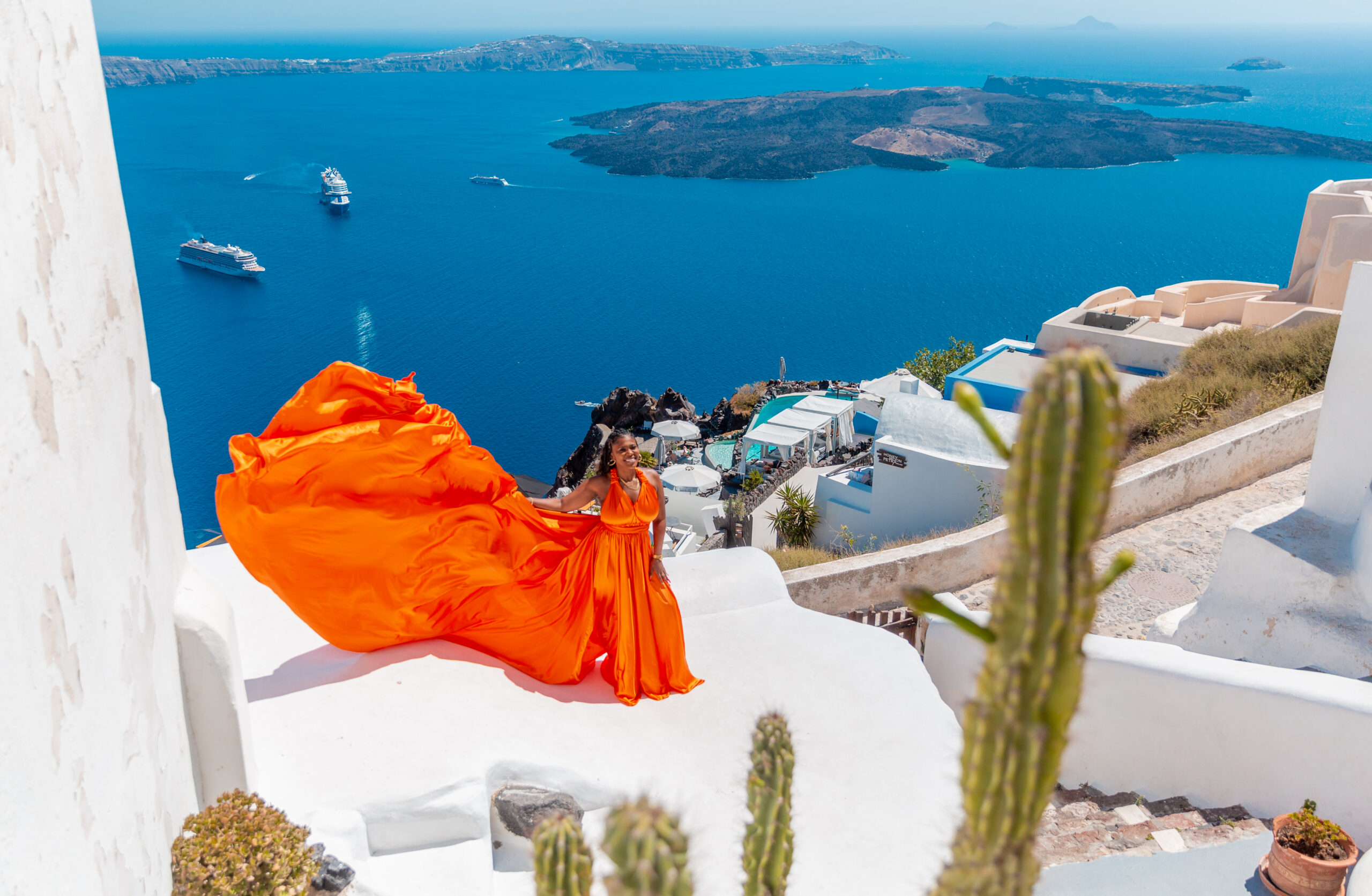 Santorini Photographer. Santorini photo shoot with flying dress. Santorini Photoshoot. Flying Dress Photoshoot in Santorini. Santorini Photography. Group Santorini photoshoot