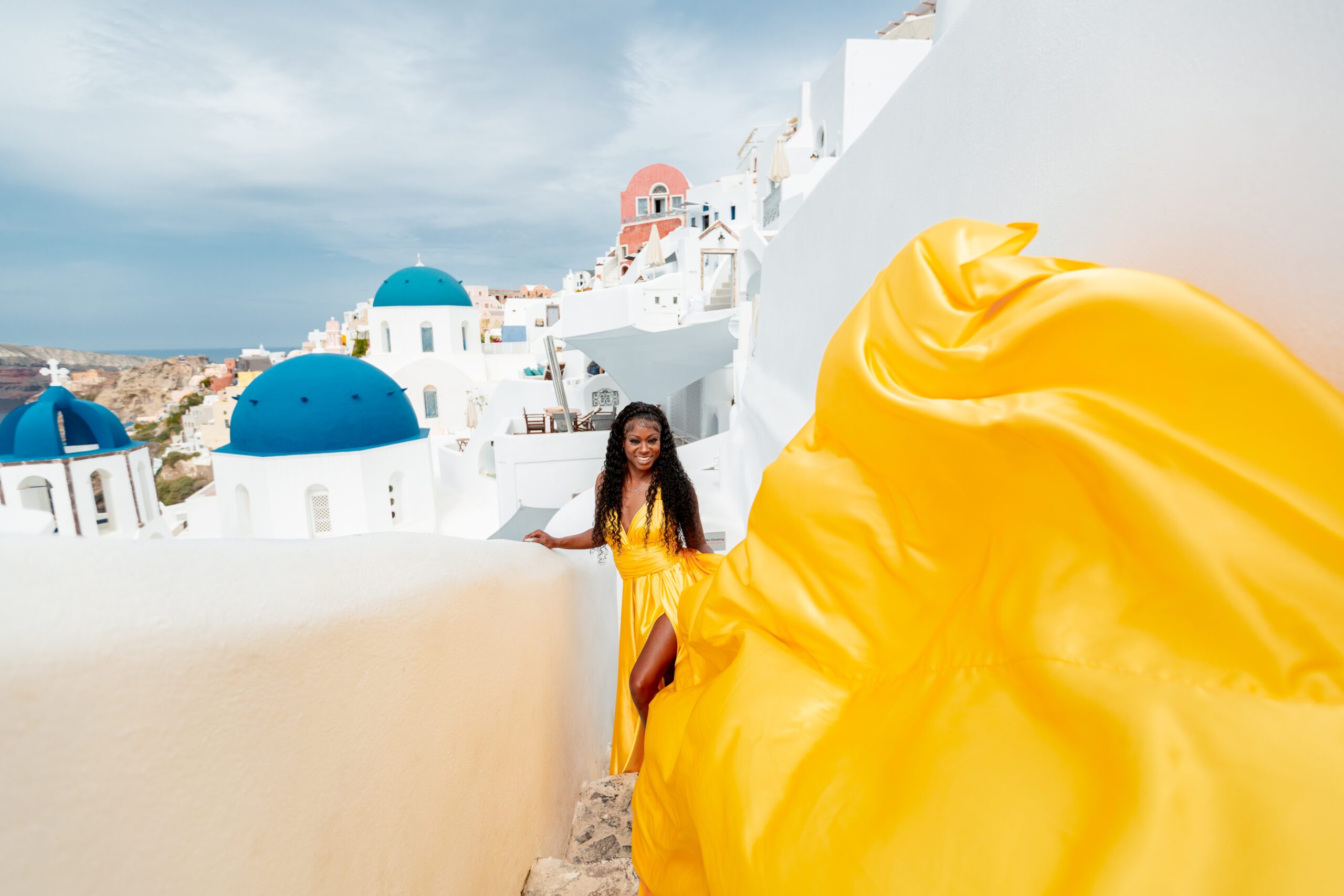 Santorini Photographer. Santorini photo shoot with flying dress. Santorini Photoshoot. Flying Dress Photoshoot in Santorini. Santorini Photography. Group Santorini photoshoot