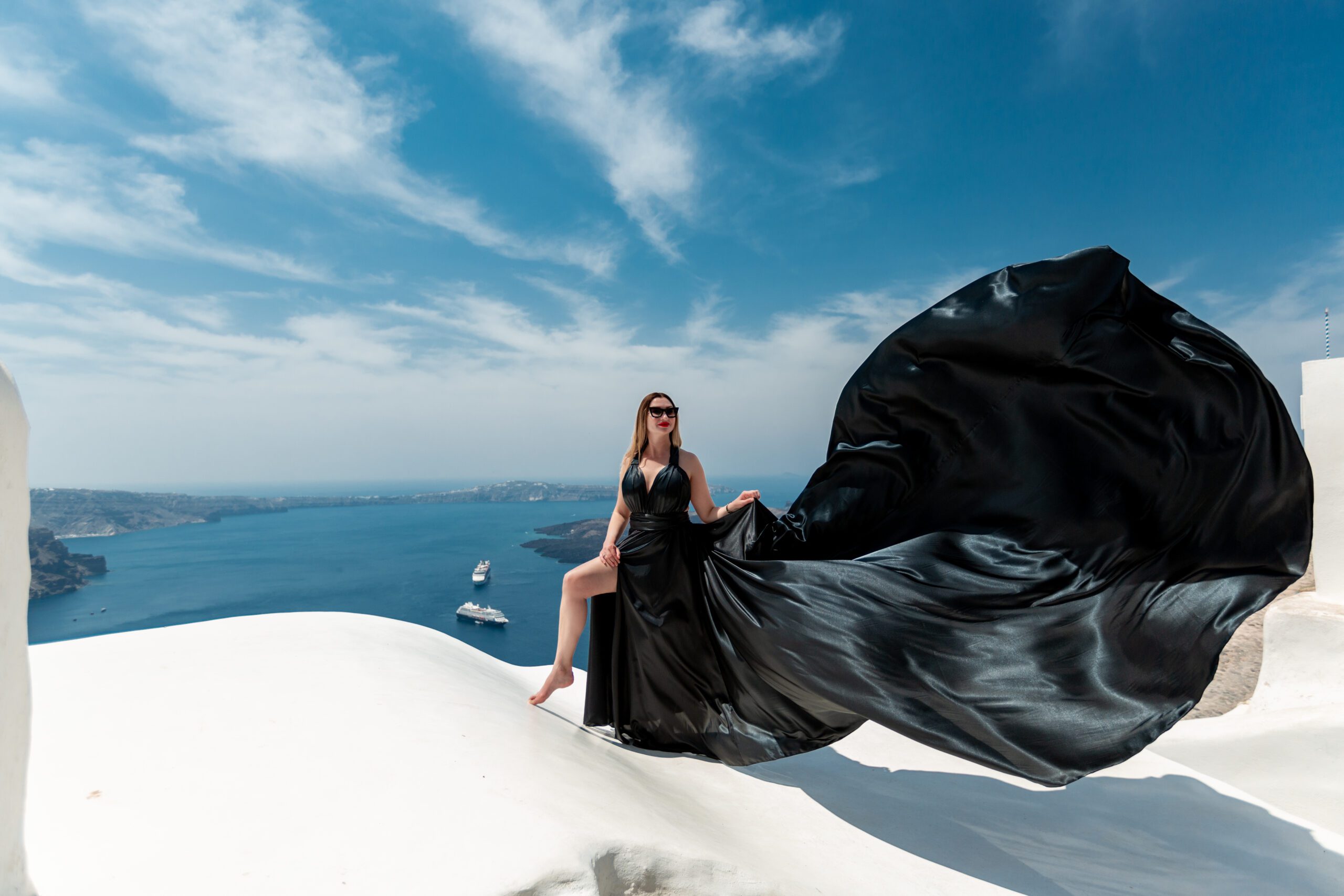Santorini Photographer. Santorini photo shoot with flying dress. Santorini Photoshoot. Flying Dress Photoshoot in Santorini. Santorini Photography. Group Santorini Photoshoot