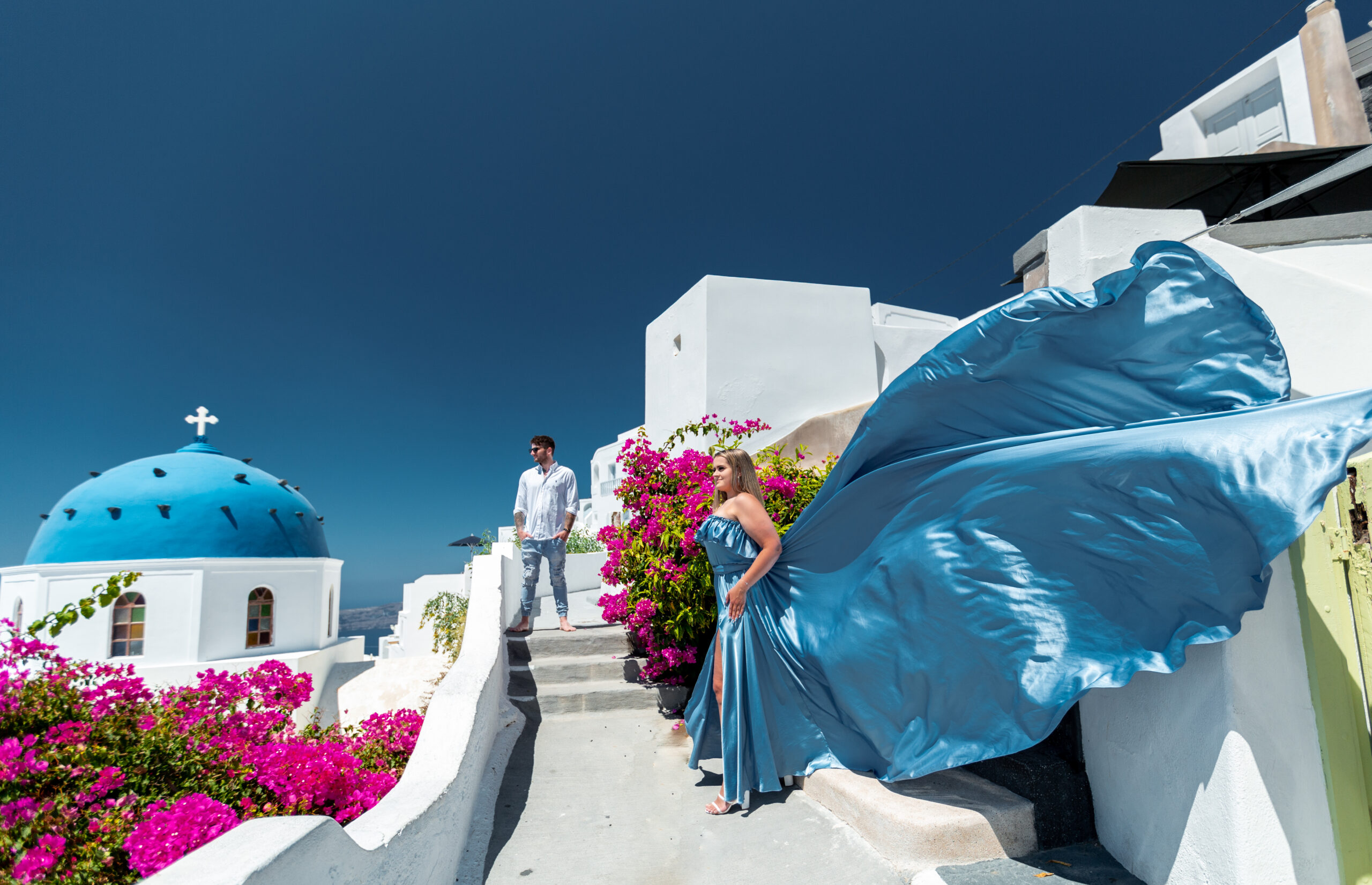 Santorini Photographer. Santorini photo shoot with flying dress. Santorini Photoshoot. Flying Dress Photoshoot in Santorini. Santorini Photography. Group Santorini photoshoot