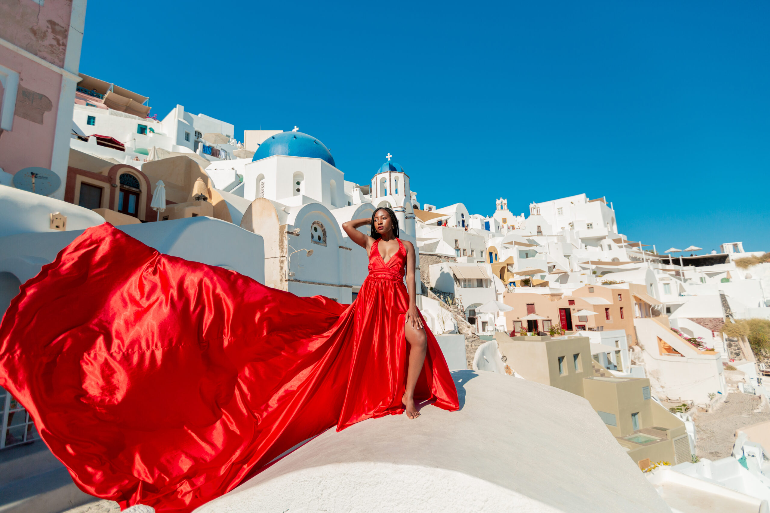 Santorini Photographer. Santorini photo shoot with flying dress. Santorini Photoshoot. Flying Dress Photoshoot in Santorini. Santorini Photography. Group Santorini photoshoot