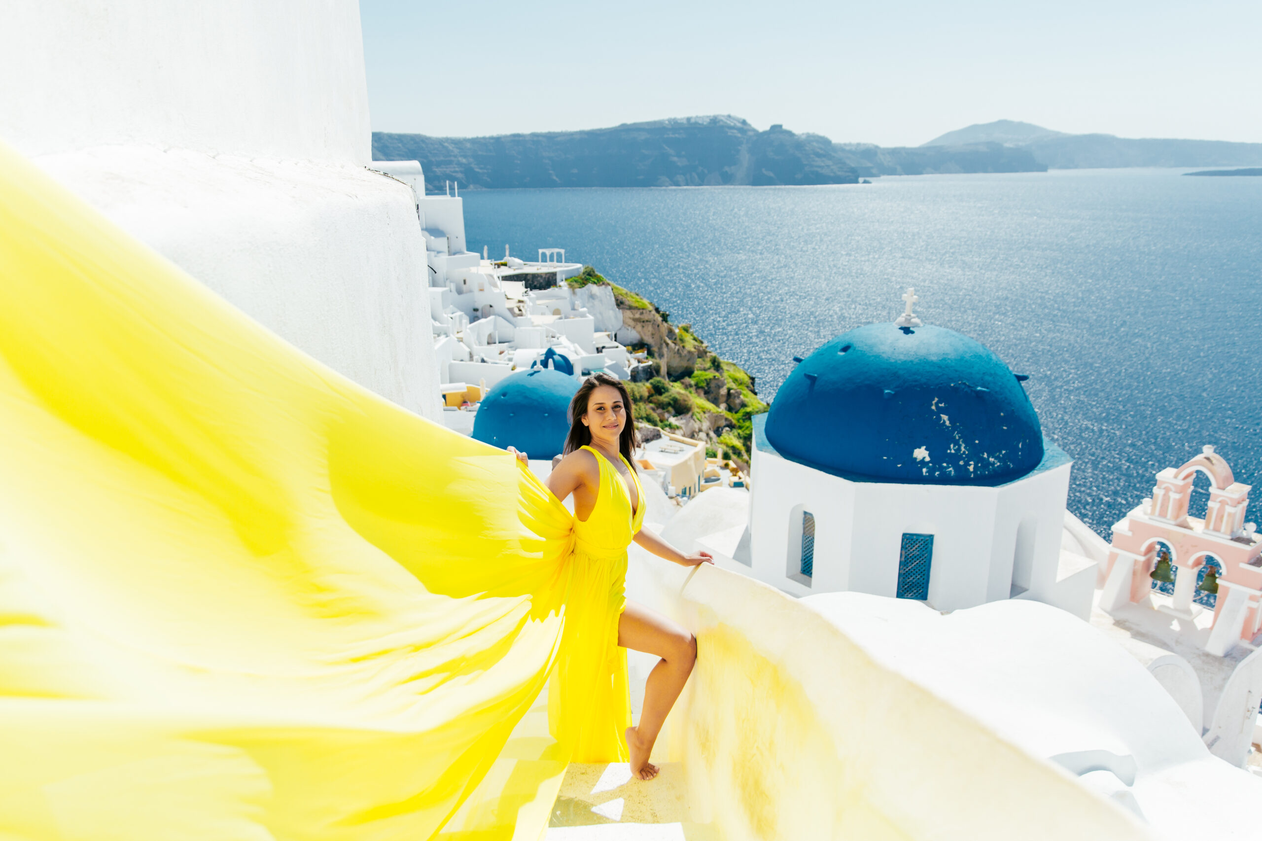 Santorini Photographer. Santorini photo shoot with flying dress. Santorini Photoshoot. Flying Dress Photoshoot in Santorini. Santorini Photography. Group Santorini photoshoot