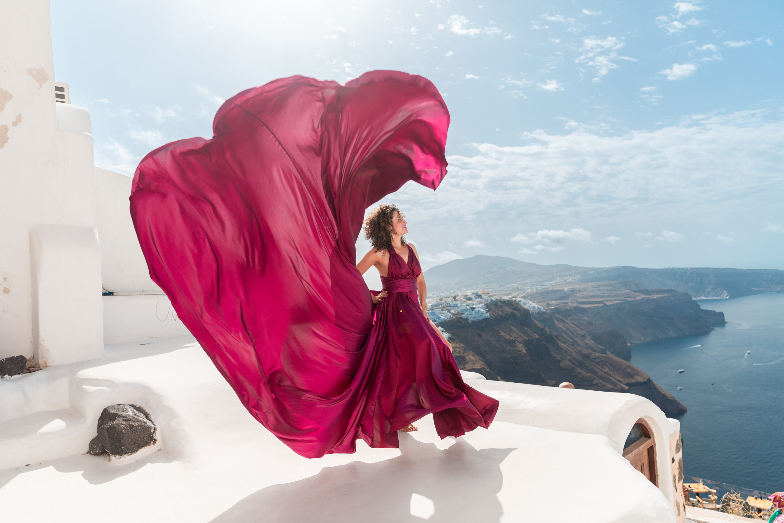 Santorini Photographer. Santorini photo shoot with flying dress. Santorini Photoshoot. Flying Dress Photoshoot in Santorini. Santorini Photography. Group Santorini photoshoot