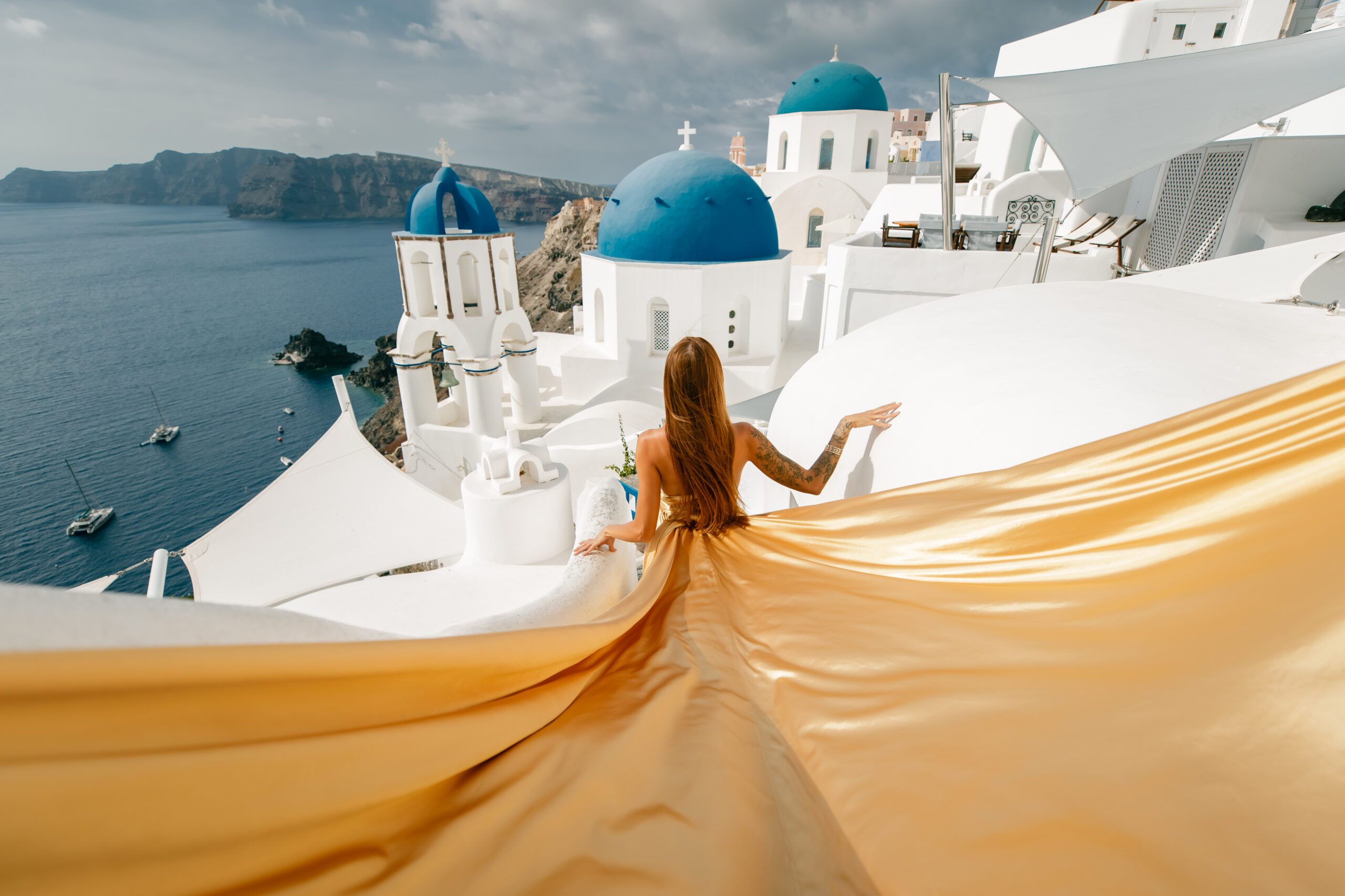 Santorini Photographer. Santorini photo shoot with flying dress. Santorini Photoshoot. Flying Dress Photoshoot in Santorini. Santorini Photography. Group Santorini photoshoot