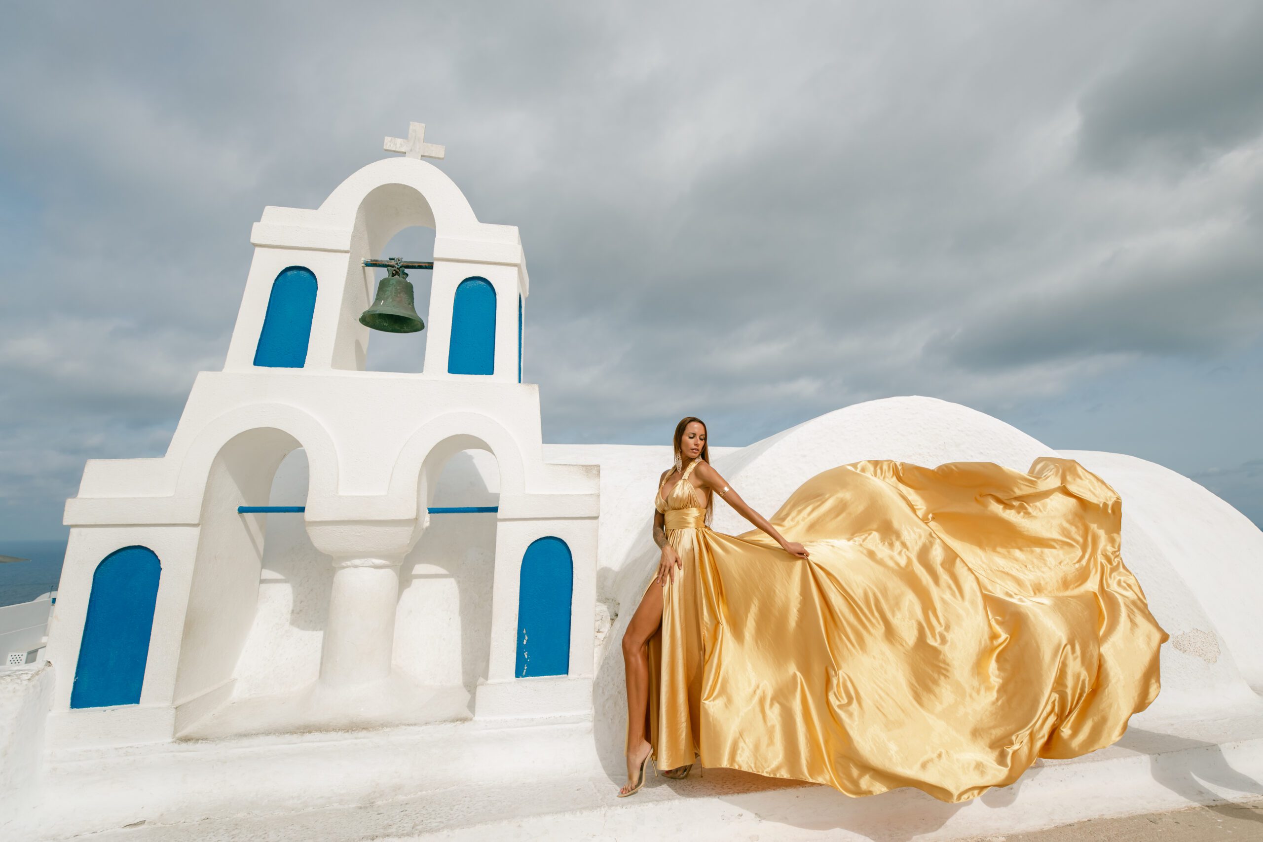 Santorini Photographer. Santorini photo shoot with flying dress. Santorini Photoshoot. Flying Dress Photoshoot in Santorini. Santorini Photography. Group Santorini photoshoot